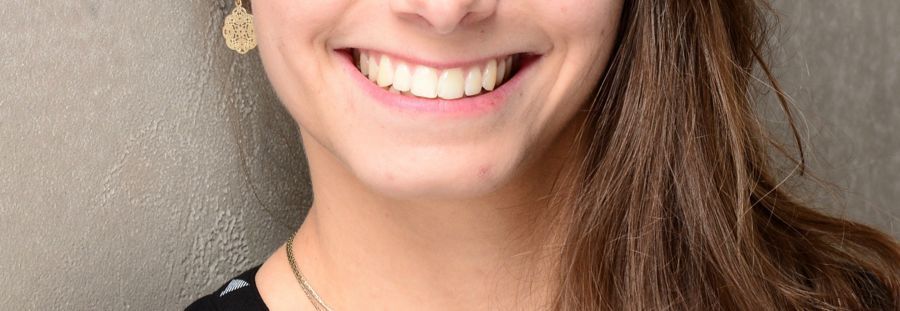 Lächelnde Person mit langen braunen Haaren